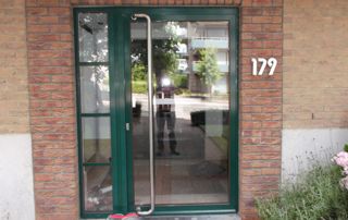 porte d'entrée immeuble vitrée avec châssis vert